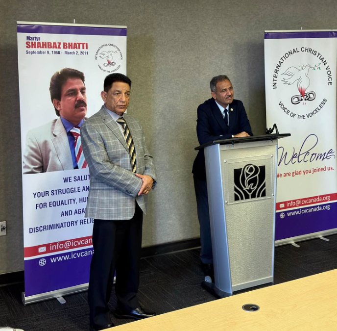 Two speakers at the podium beside the Martyr Shahbaz Bhatti banner at Brampton City Hall.